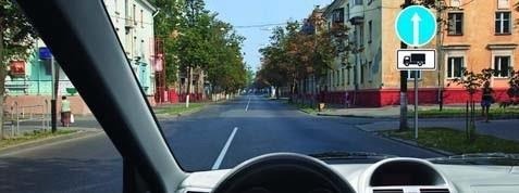 In which direction is the driver of a passenger car permitted to travel in this situation?